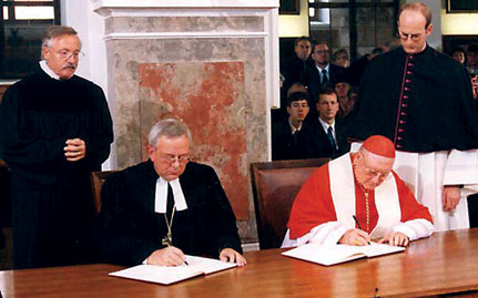 1999년 독일 아우크스부르크에서 열린 '칭의교리에 관한 공동선언' 조인식. 루터교세계연맹의 당시 의장 크리스티안 크라우제 주교(왼쪽)와 바티칸 교회일치평의회의 당시 위원장 에드워즈 캐시디 추기경이 서명하고 있다.사진/ 루터교세계연맹(LWF)