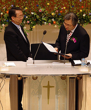 새로남교회 오정호 목사가 임직자들의 헌금을 총신 김인환 총장에게 장학금으로 전달하고 있다.