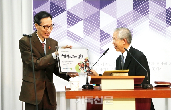 기아대책 손봉호 이사장이 성덕중앙교회 김준수 목사(왼쪽)에게 기념현판을 증정하고 있다.